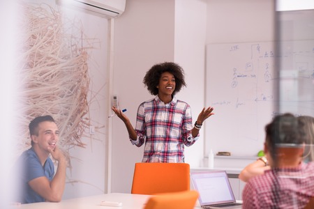 Multiethnic startup business team on meeting in modern bright office interior brainstorming, working on laptop and tablet computerの写真素材