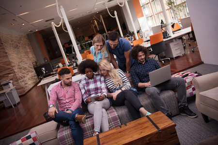 Multiethnic startup business team on meeting in modern bright office interior brainstorming, working on laptop and tablet computerの写真素材