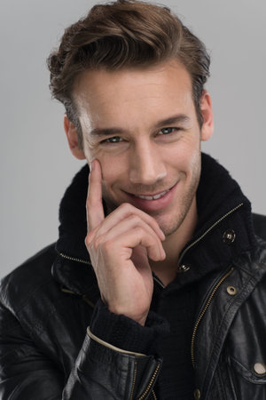 Fashion man, Handsome serious beauty male model portrait wear leather jacket, young guy over gray backgroundの写真素材