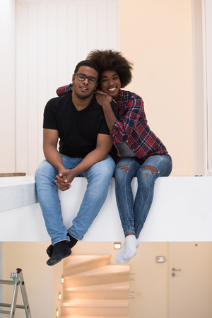 Happy young African American couple having break during moving to new houseの写真素材