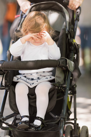 little and very beautiful baby girl sitting in the pram and waiting for mom