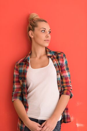 Portrait of a beautiful  young woman with hair bun over color background with copyspace expressing different emotionsの写真素材