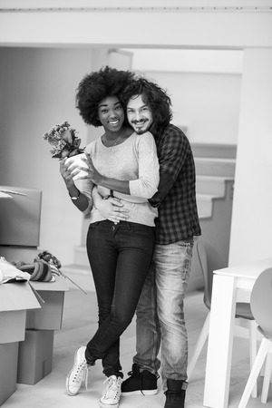 Happy young multiethnic couple unpacking or packing boxes and moving into a new homeの写真素材