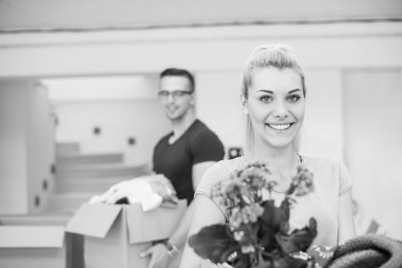 Happy young couple unpacking or packing boxes and moving into a new home