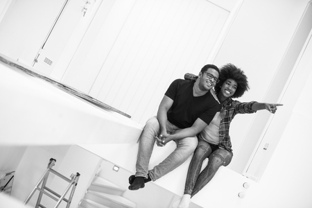 Happy young African American couple having break during moving to new houseの写真素材