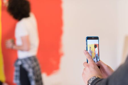 happy smiling young couple painting interior wall of new houseの写真素材