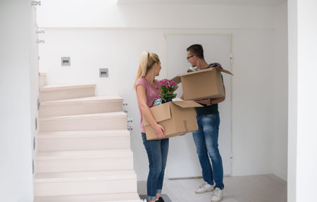 Happy young couple unpacking or packing boxes and moving into a new home