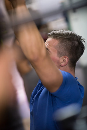 Fitness handsome man doing dipping exercise using rings in the gym