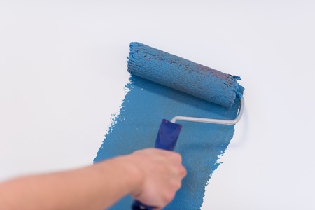 Decorator's hand painting wall with rollerの写真素材