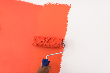 Decorator's hand painting wall with rollerの写真素材