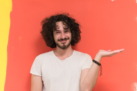Portrait of a beautiful  young man with funny hair over color background with copyspace expressing different emotionsの写真素材