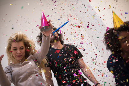 confetti party Multiethnics happy young people group celebrating new year eve while dancing and have fun at homeの写真素材