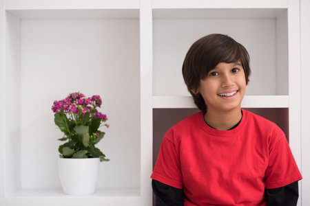 happy young boy having fun while posing on a shelf in a new modern home