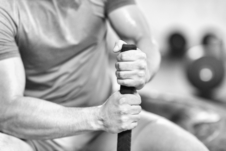 young muscular man after workout at gym with hammer and tractor tire with a focus on handsの写真素材