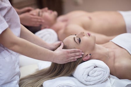 happy young beautiful couple enjoying head massage at the spaの写真素材