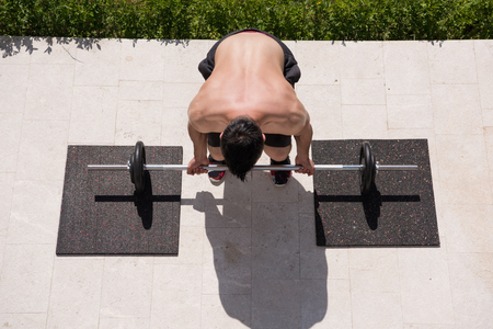 young handsome man doing morning exercises in front of his luxury home villaの写真素材