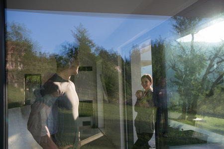 young beautiful handsome couple enjoying morning coffee on the door of their luxury home villa
