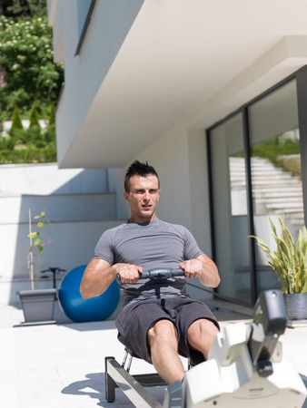 young handsome man doing morning exercises in front of his luxury home villaの写真素材