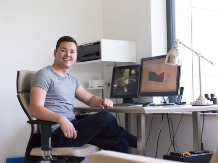 portrait of security system operator looking at CCTV footage at desk in office