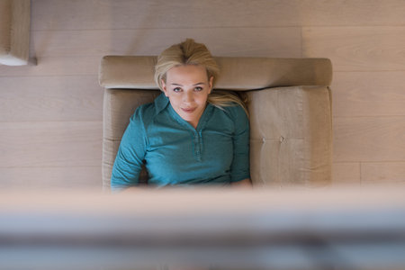 young happy woman on sofa using tablet computer at luxury home