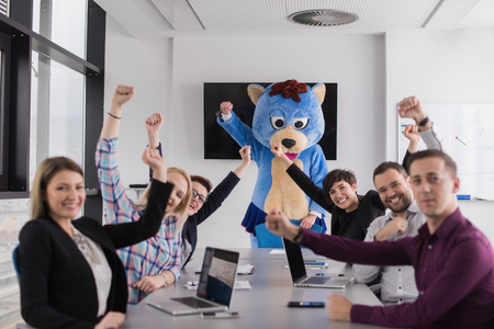 Boss dresed as teddy bear having fun with bussines people in modern corporate officeの写真素材