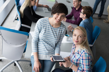 Business Women Using Digital Tablet in Busy Office
