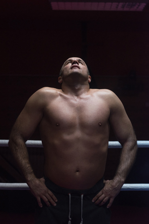 portrait of muscular professional kickboxer who standing in the ring while training for the fightの写真素材