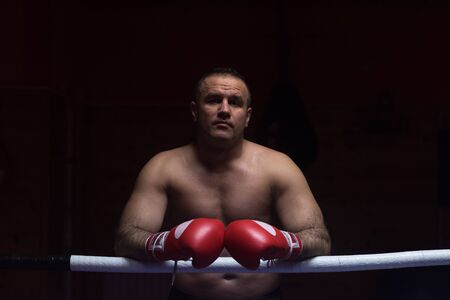 portrait of muscular professional kickboxer who standing in the ring while training for the fightの写真素材