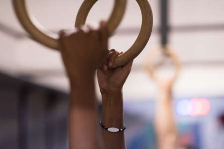 Cropped shot of male hands on gymnastics ringsの写真素材