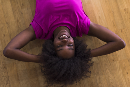 happy african american woman with a curly afro hairstyle in a  gym relaxing after pilates workoutの写真素材