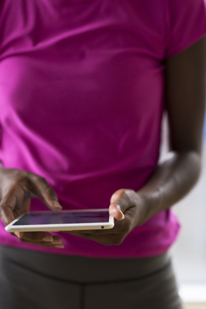 beautiful african american woman using tablet computer from home while rain and bad weather is outdoorの写真素材