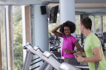 young people exercisinng a cardio on treadmill running machine in modern gymの写真素材