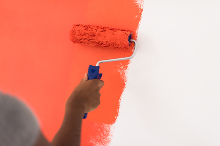 Decorator's hand painting wall with rollerの写真素材
