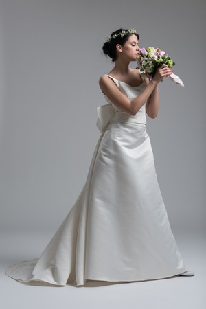 Young attractive bride with the a bouquet of flowers isolated on white background.の写真素材