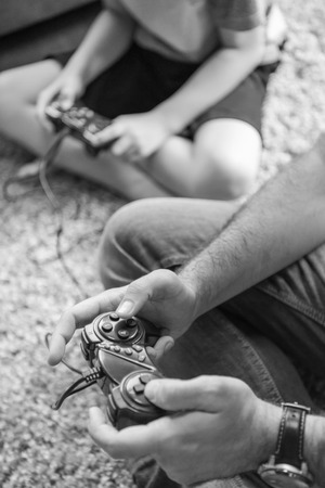 Happy family. Father, mother and children playing a video game Father and son playing video games together on the floorの写真素材