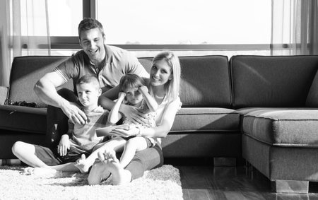 Happy Young Family Playing Together with tablet at home sitting on the sofaの写真素材