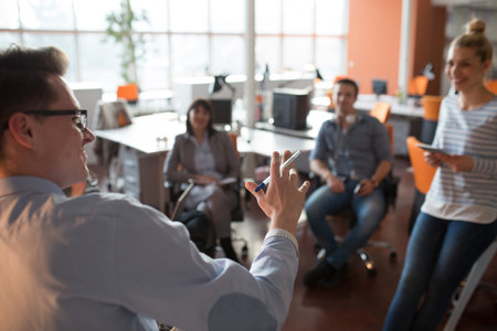 Group of a young business people discussing business plan  in the office