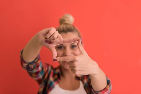 Portrait of a beautiful  young woman with hair bun over color background with copyspace expressing different emotionsの写真素材