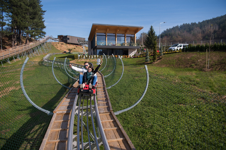 Excited young couple enjoys driving on alpine coasterの写真素材