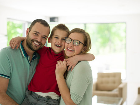 happy young family with little boy enjoys in the modern living room of their luxury home villaの写真素材