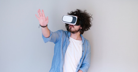Happy man getting experience using VR headset glasses of virtual reality, isolated on white backgroundの写真素材