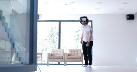 happy man getting experience using VR-headset glasses of virtual reality at home