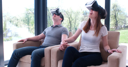 Couple using virtual reality headset in living room at home  people playing game with new trends...