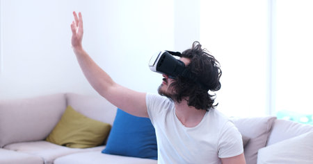 happy man getting experience using VR-headset glasses of virtual reality at home
