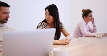Group of a young business people discussing business plan at modern startup office building