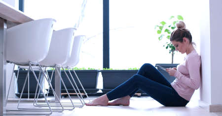 beautiful young women using tablet computer on the floor of her luxury homeの写真素材