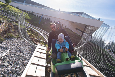 Excited father and son enjoys driving on alpine coaster