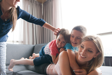 Happy Mother with kids having fun on the floor at homeの写真素材