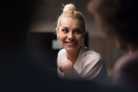 Multiethnic startup business team on meeting in modern night office interior brainstorming, working on laptopの写真素材