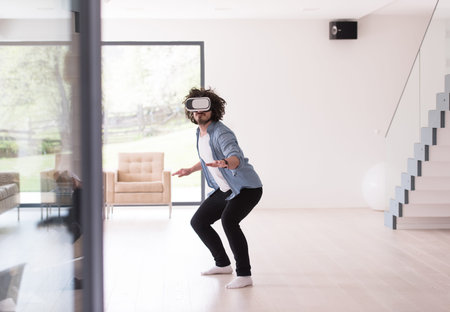 happy man getting experience using VR-headset glasses of virtual reality at home